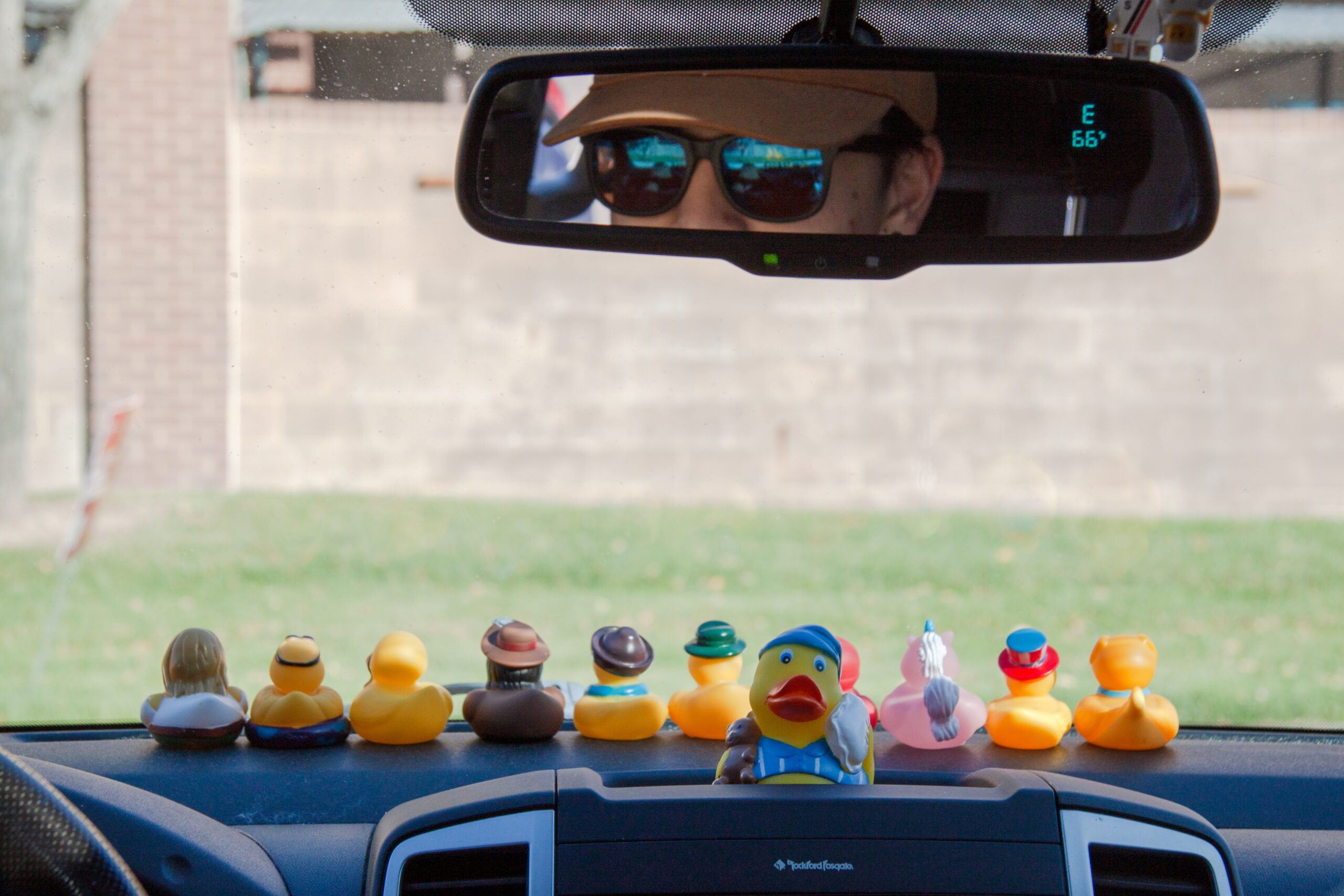 Before edits. Dashboard of a car with rubber ducks on it.
